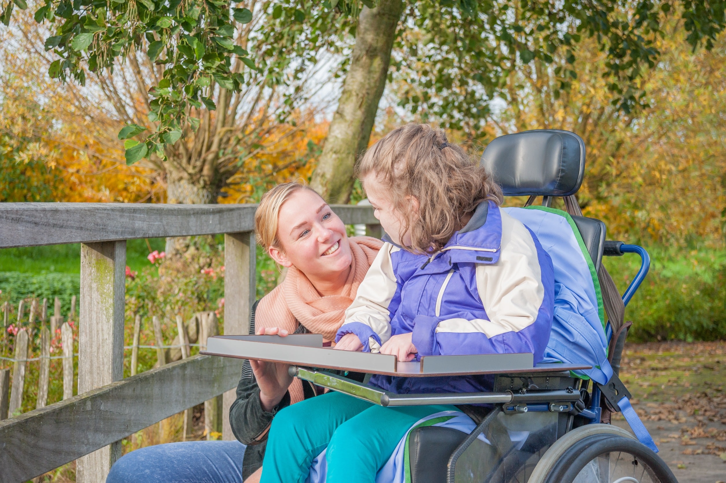 Child seated in wheelchair looking at parent or caregiver