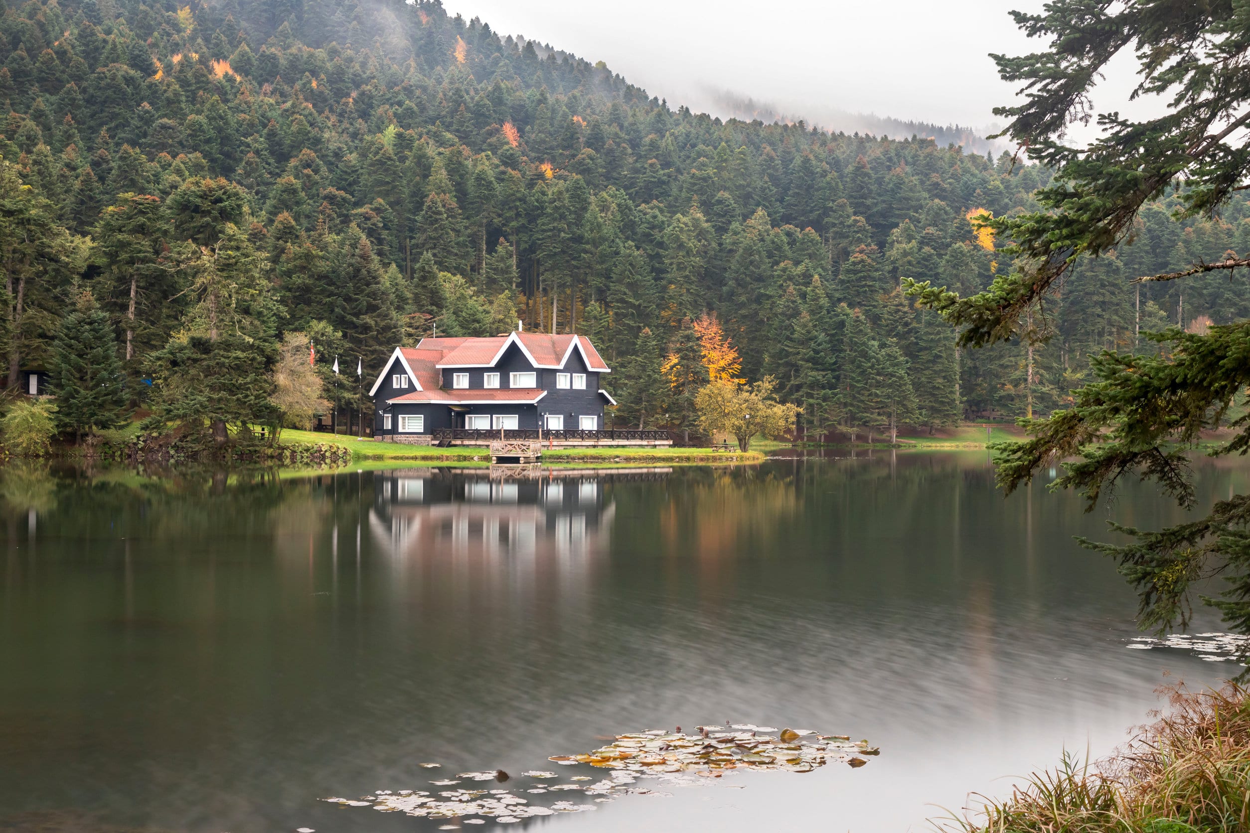 House on lake in front of mountains