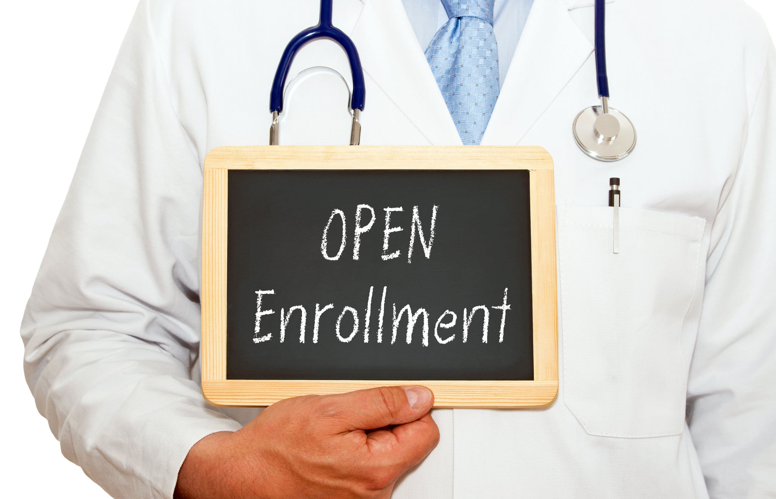 Doctor wearing a white coat and holding a chalkboard that says "Open Enrollment"