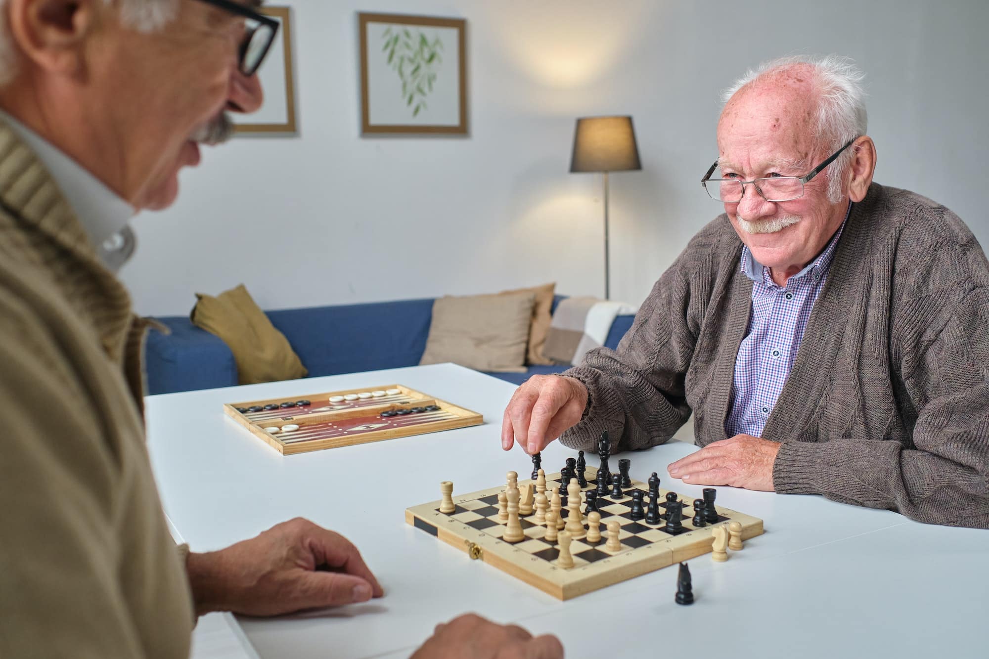 Elderly men playing chess together at assisted living facility